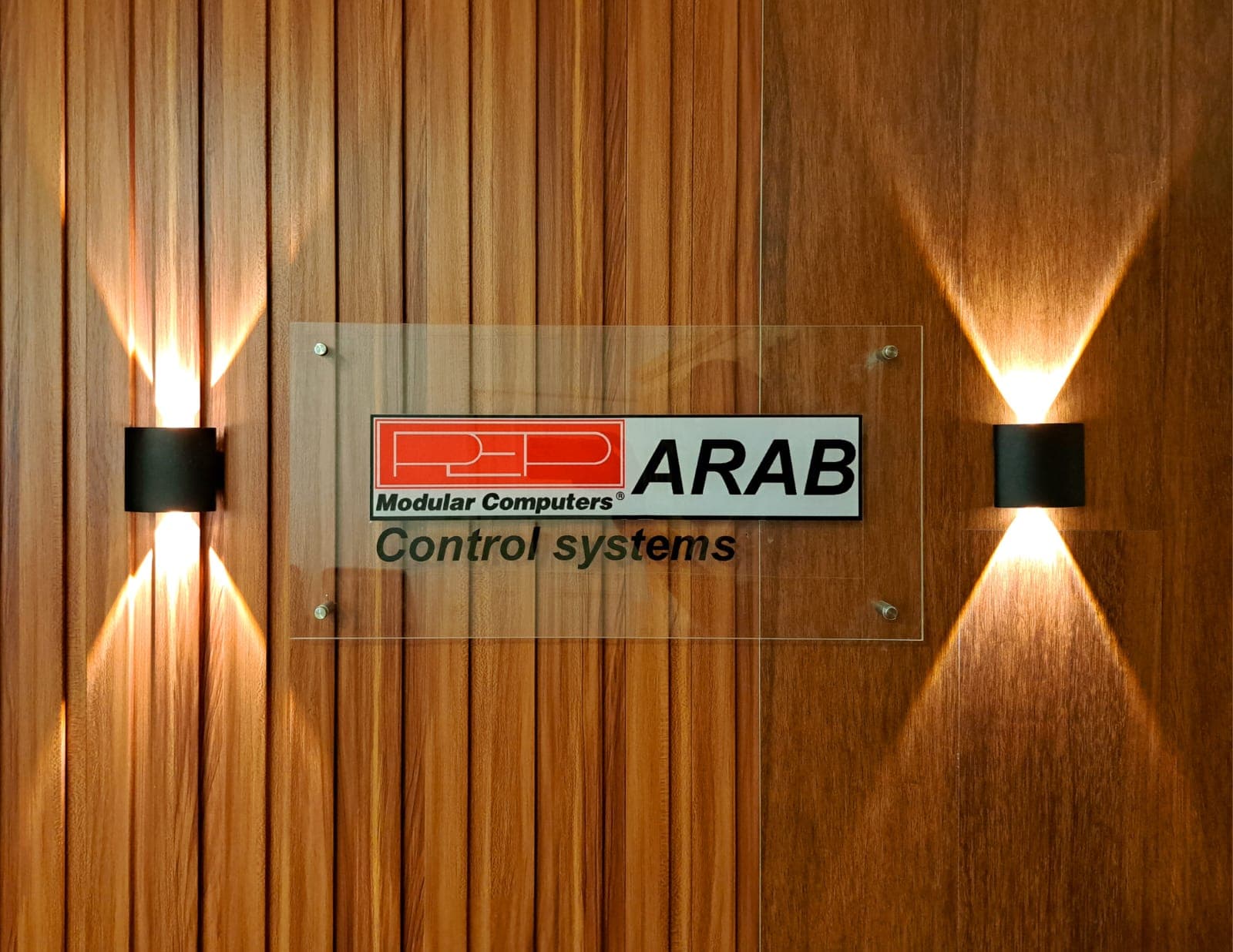 PEP ARAB signage — an illuminated acrylic plaque on a wood-panelled wall